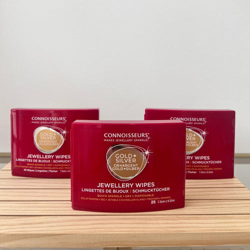 Three boxes of Connoisseurs Gold & Silver Jewellery Wipes on a wooden surface with a white background.