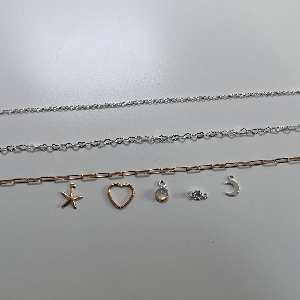  silver necklaces with various pendants on a light gray background