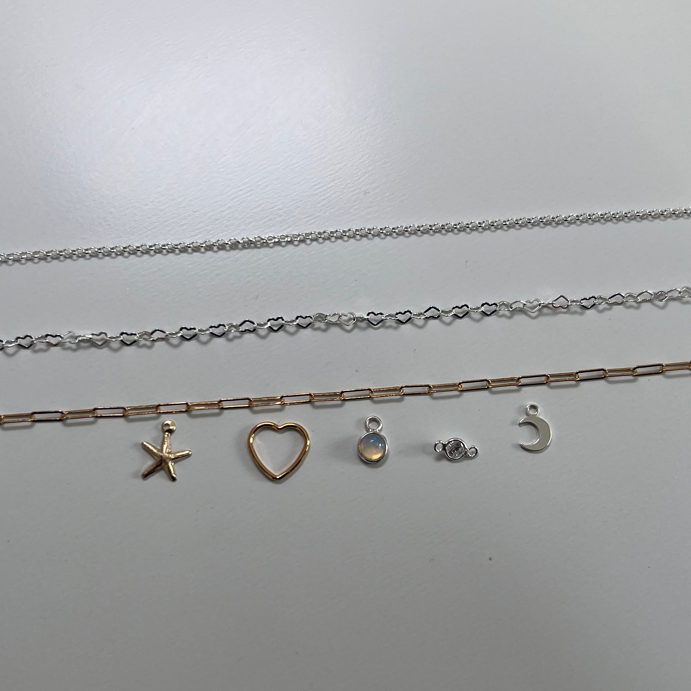 silver necklaces with various pendants on a light gray background