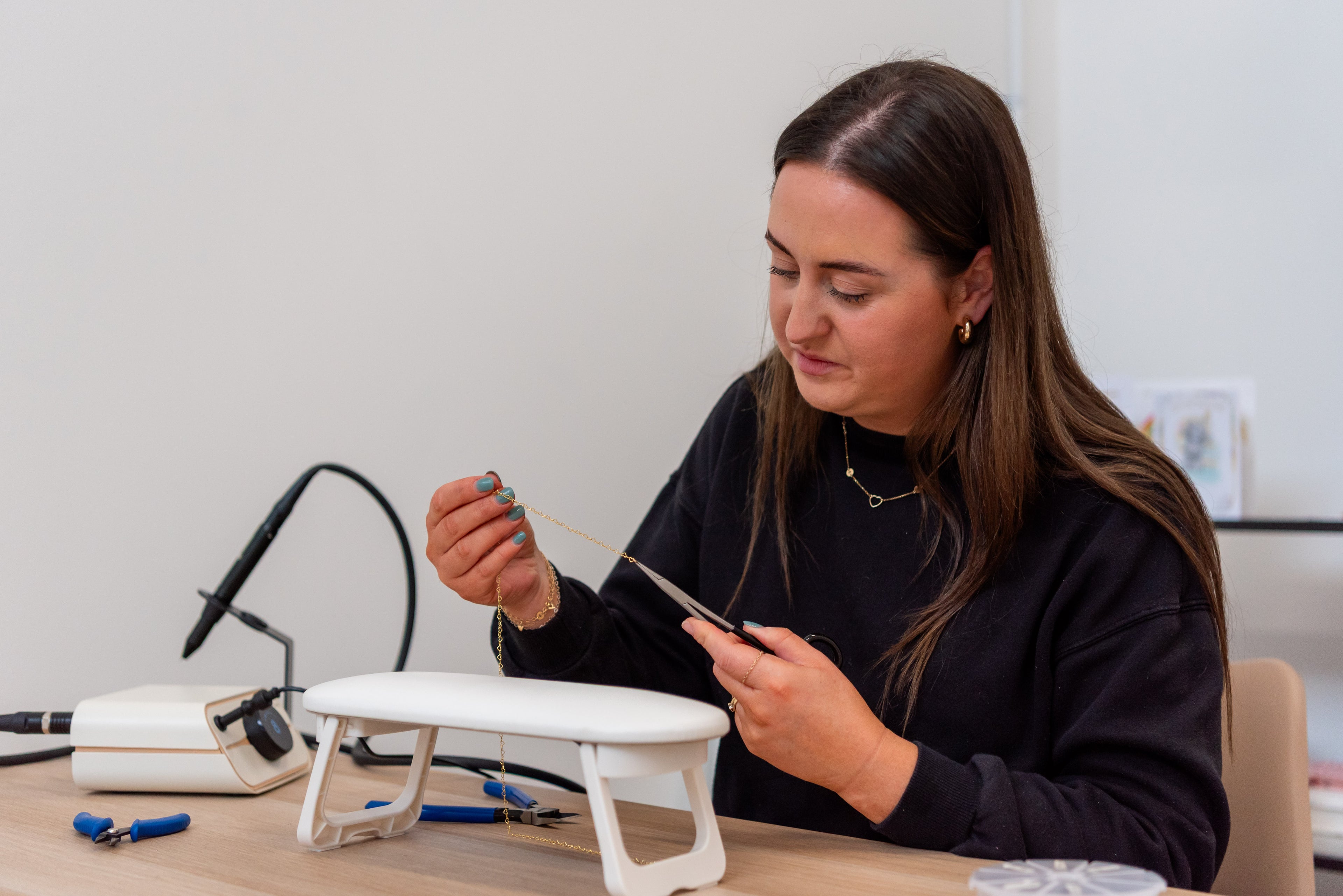 Woman working on a small electronic device at a desk
